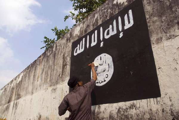 Government officials are erasing graffiti of Islamic State (ISIS) banner in Solo, Java, Indonesia.
