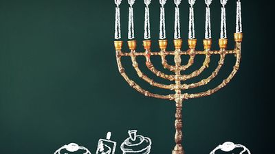 Image of jewish holiday Hanukkah with drawing menorah candles (traditional Candelabra), donuts and dreidels (spinning top) over chalkboard background. Chanukah.