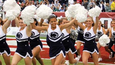 Cheerleaders run onto the football field prior to a game.