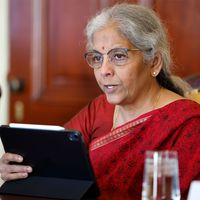 A photo of Nirmala Sitharaman, seated and dressed in red.